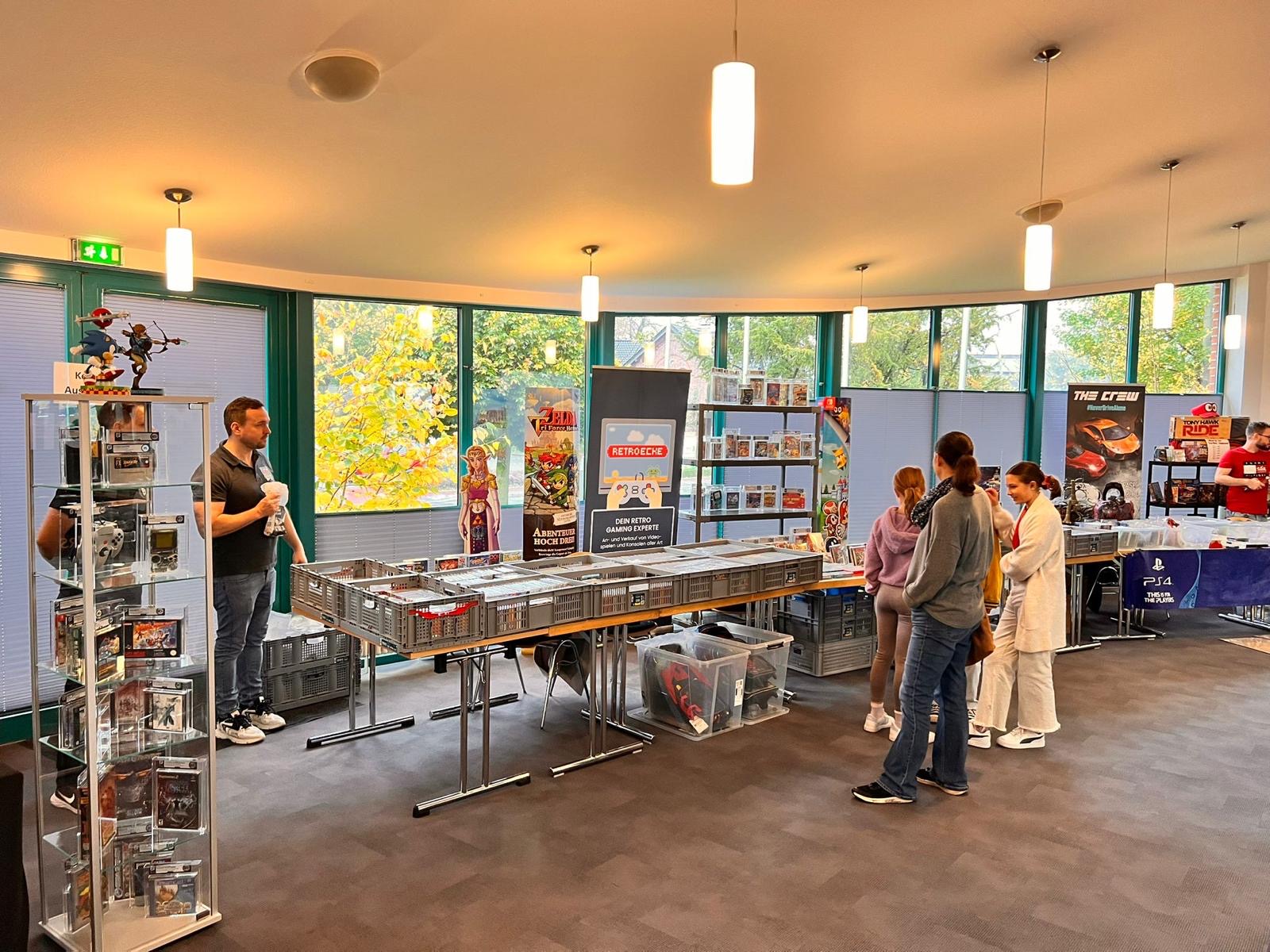 Besucher an einem Retro-Spiele-Stand 2025